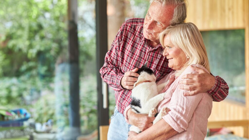 Older couple at home with their cat.