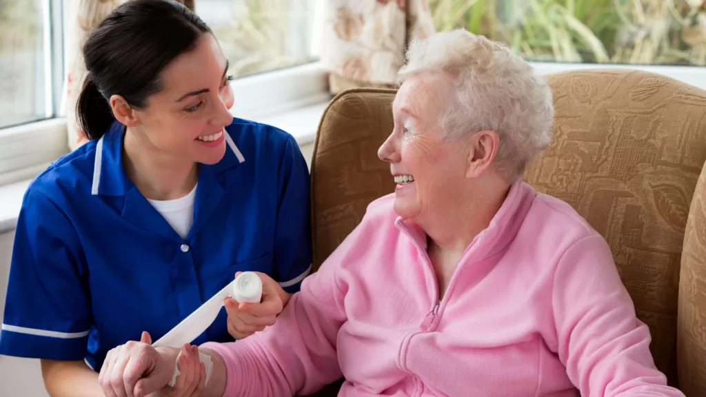 an elderly lady smiling at home with her carer